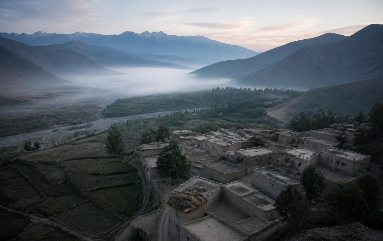 Remote valley village at dawn surrounded by mountains